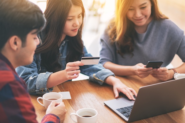 Three young asian people use credit card to purchasing and shopping online