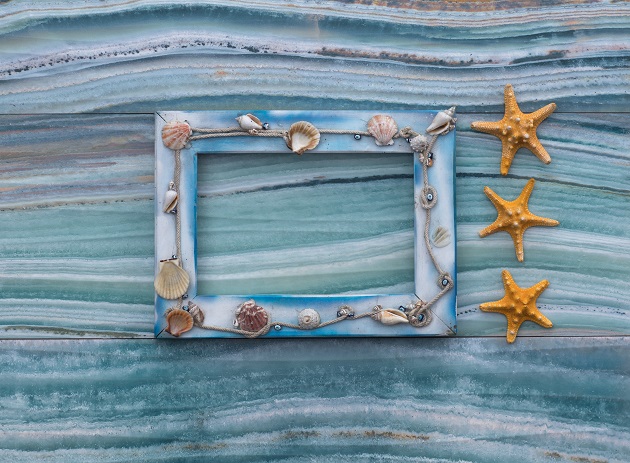 sea wooden frame with shells on sea background